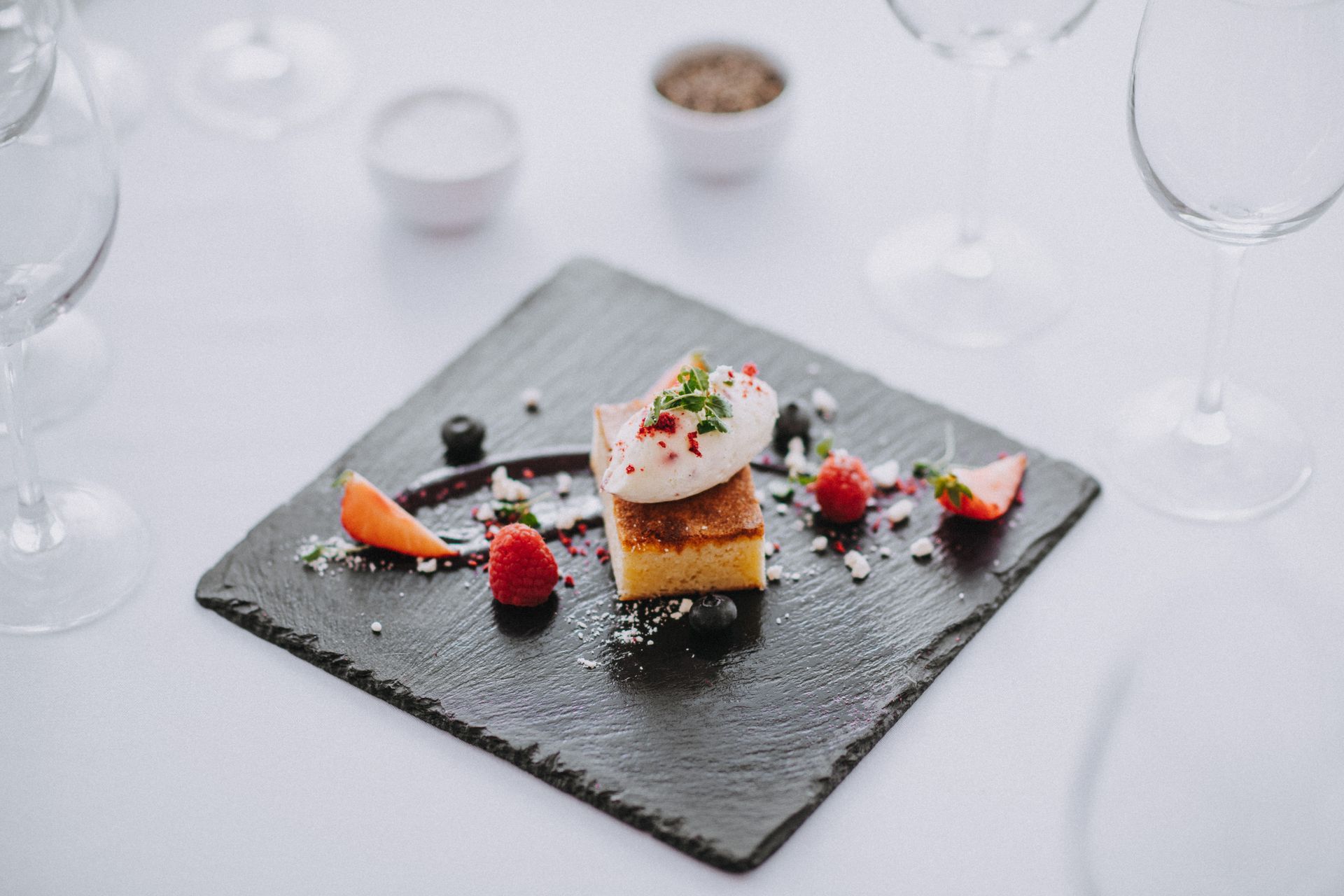 a close up of a dessert on a black plate on a table .