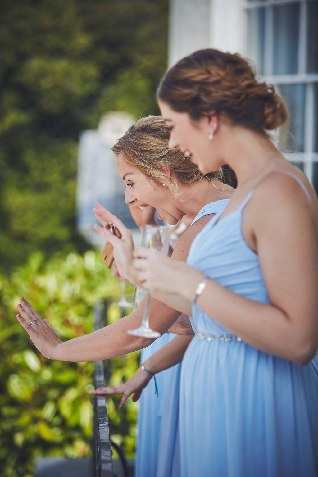 a group of bridesmaids in light blue dresses are standing next to each other holding wine glasses .
