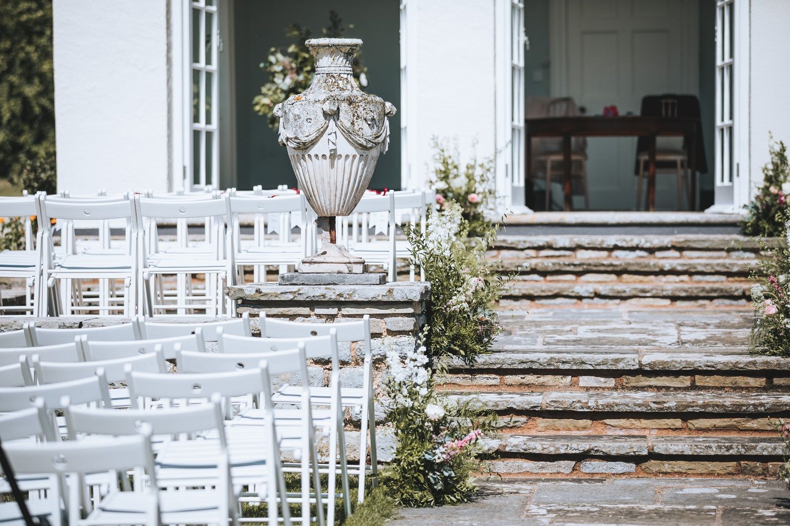 a row of white chairs are lined up in front of a white building .