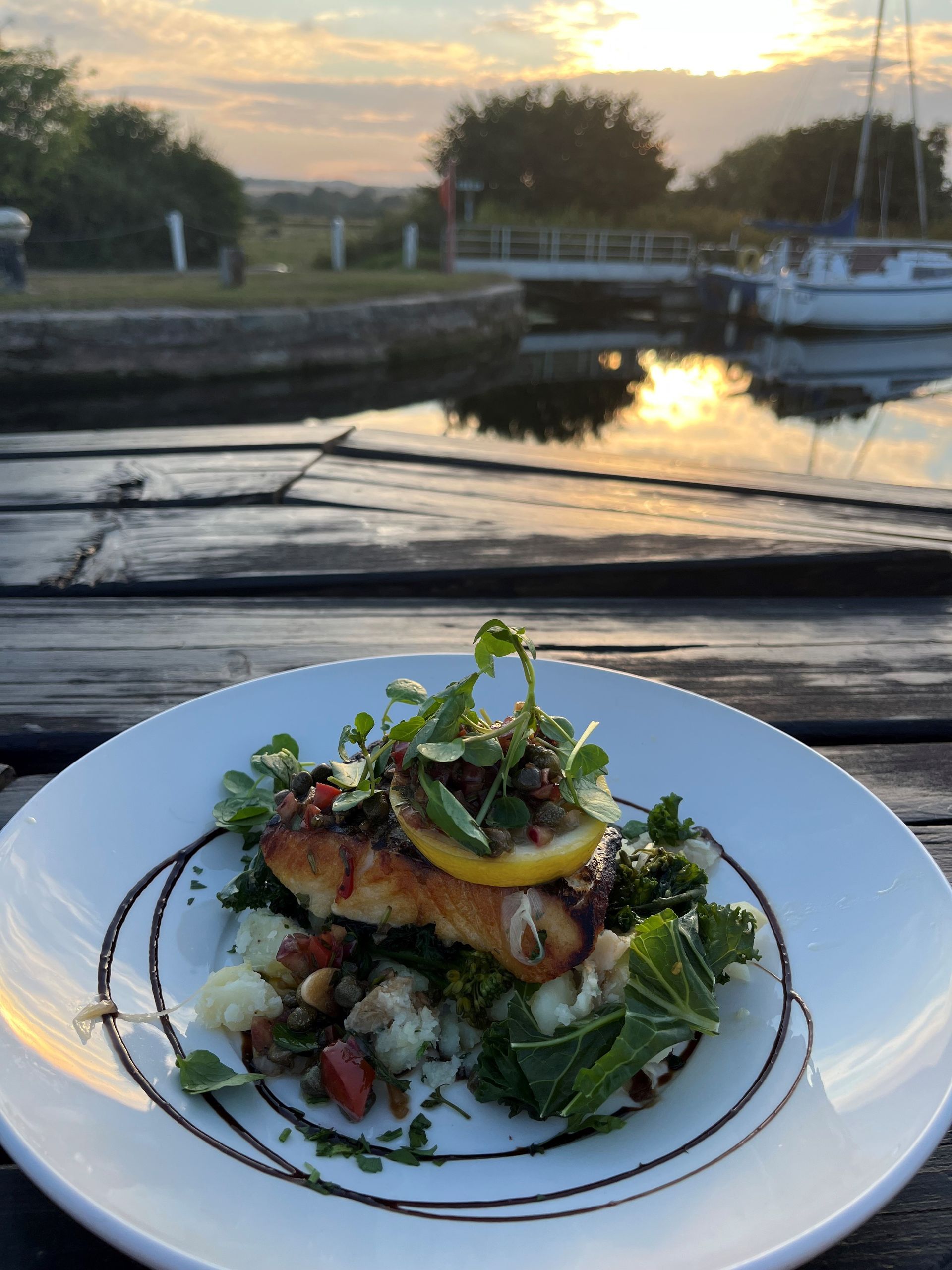 a plate of food with a boat in the background