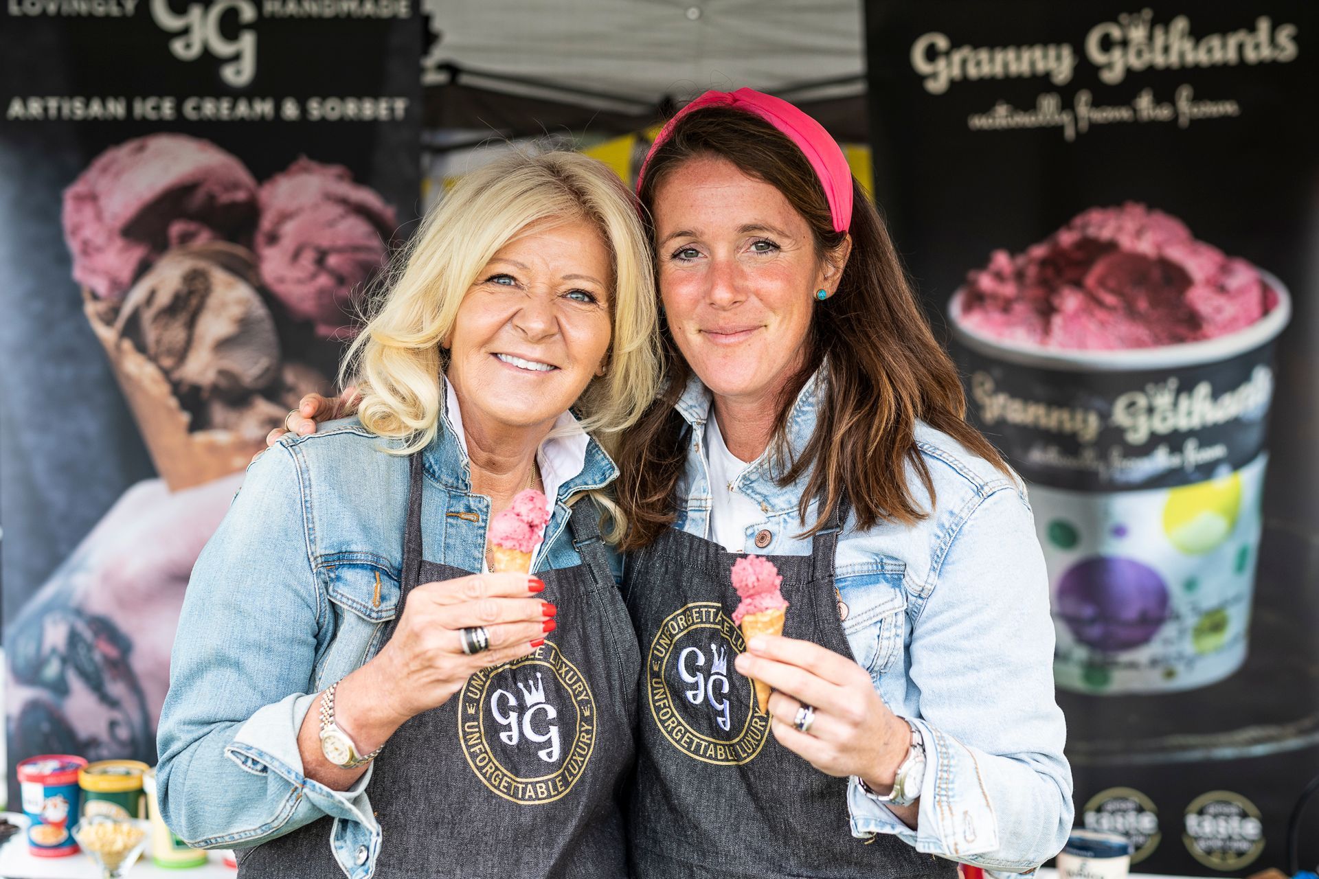 two women are standing next to each other holding ice cream cones .
