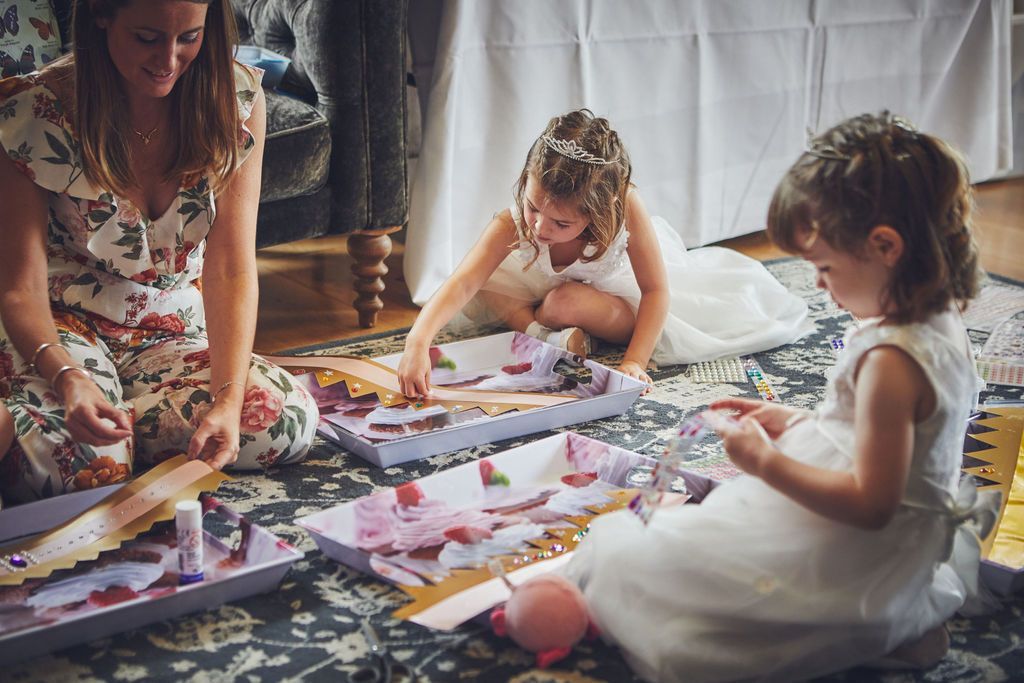 a woman and two little girls are sitting on the floor playing with toys .