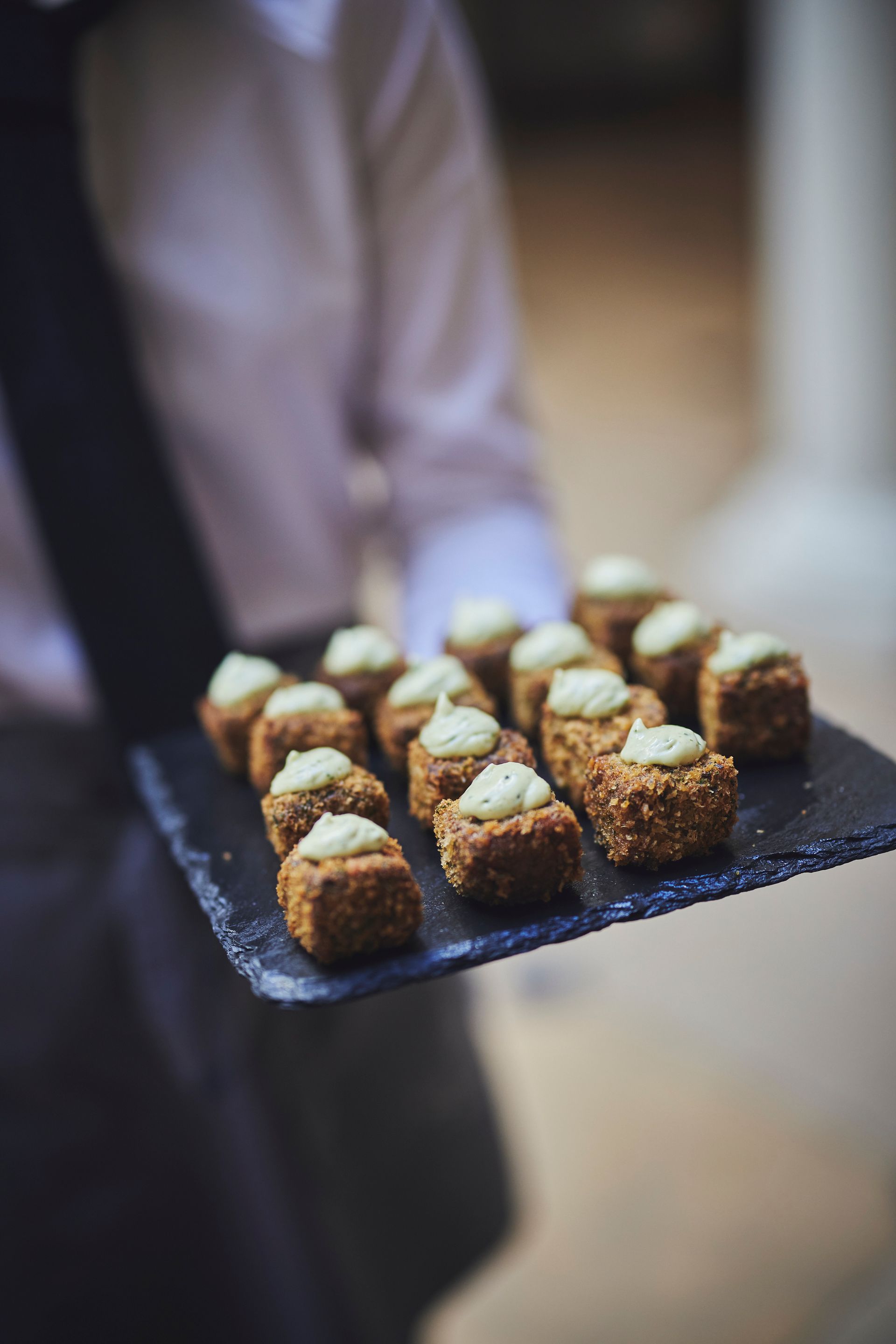 a person is holding a tray of food on a table .