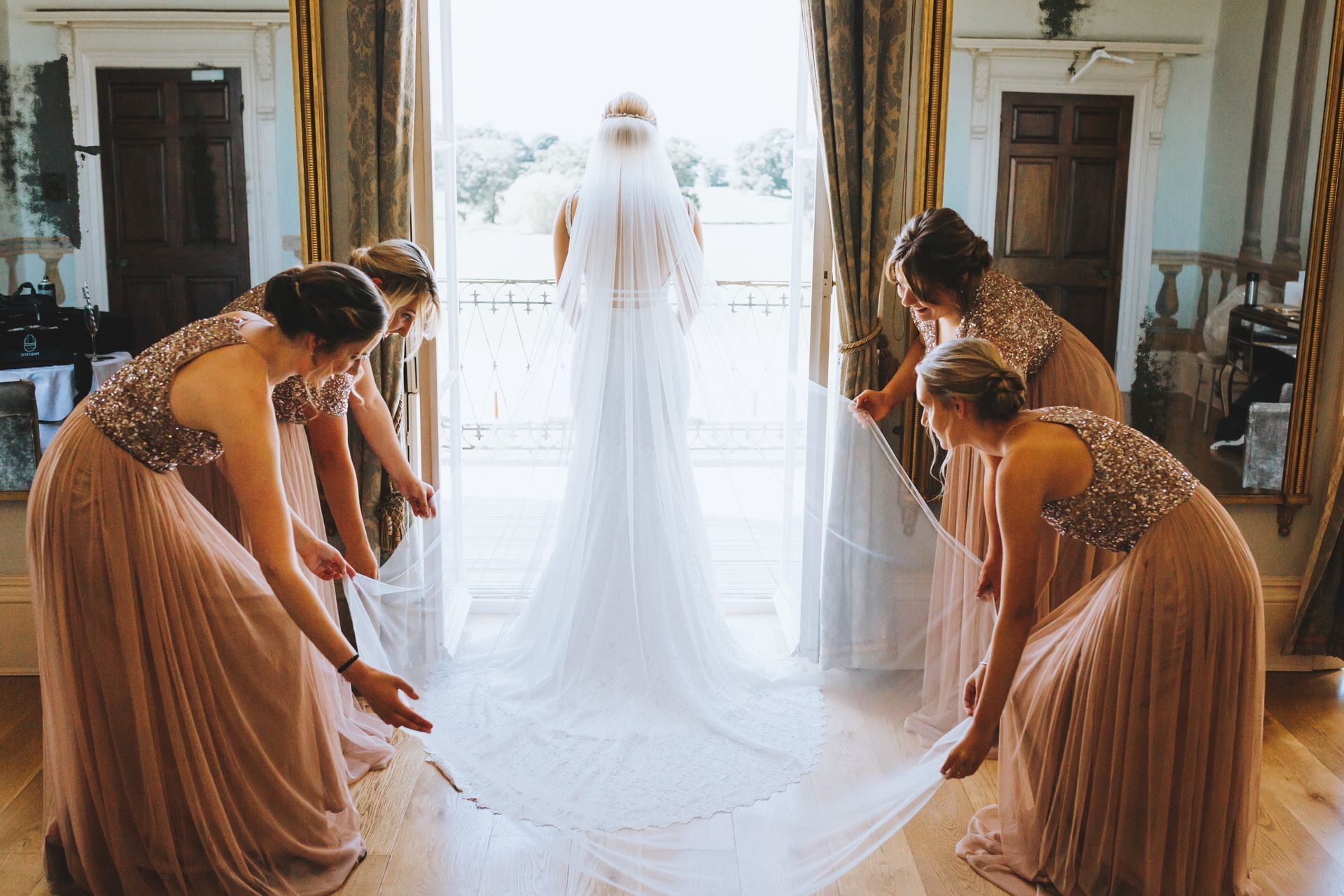 a bride and her bridesmaids are holding the wedding dress .