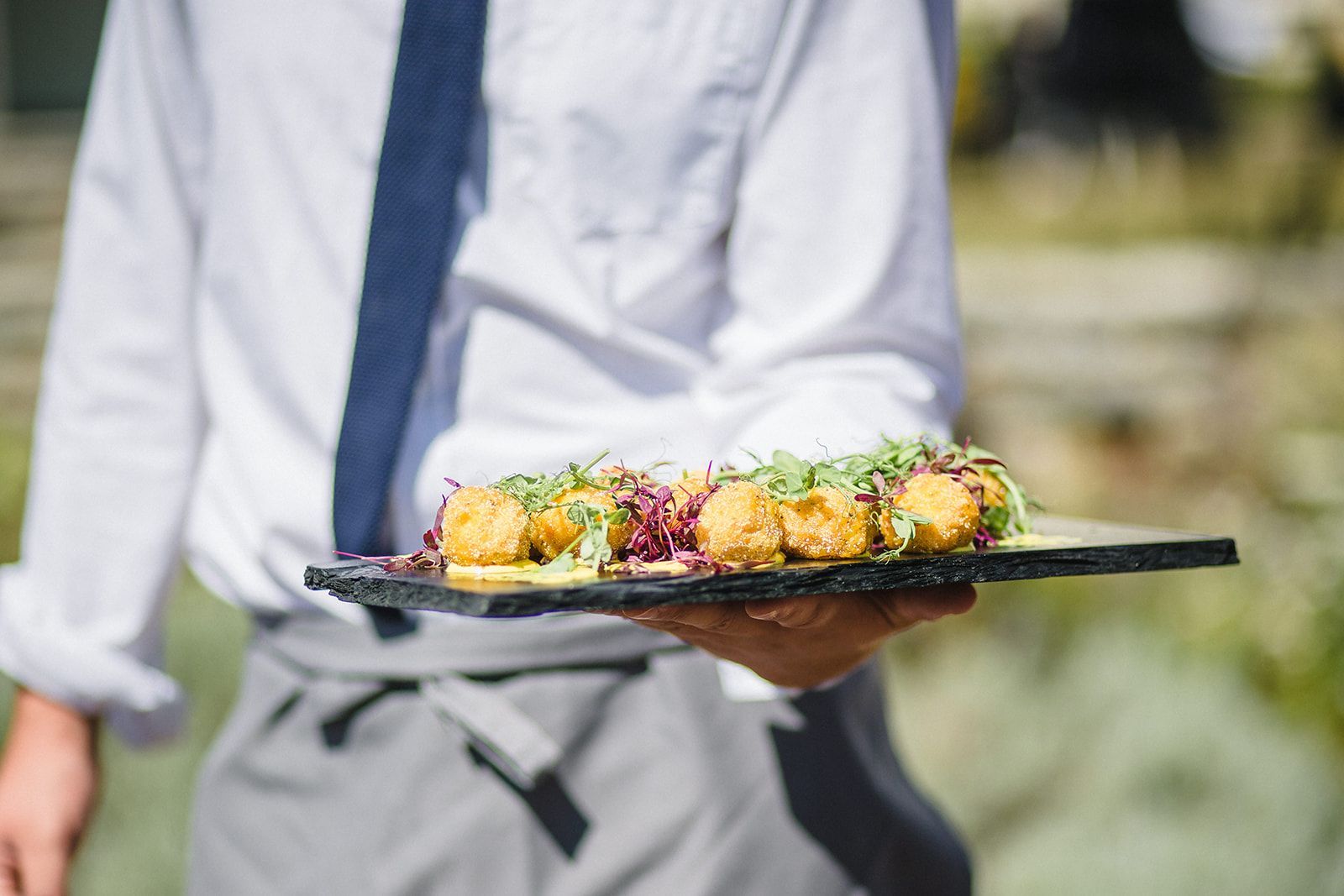 a man in a tie is holding a tray of food .