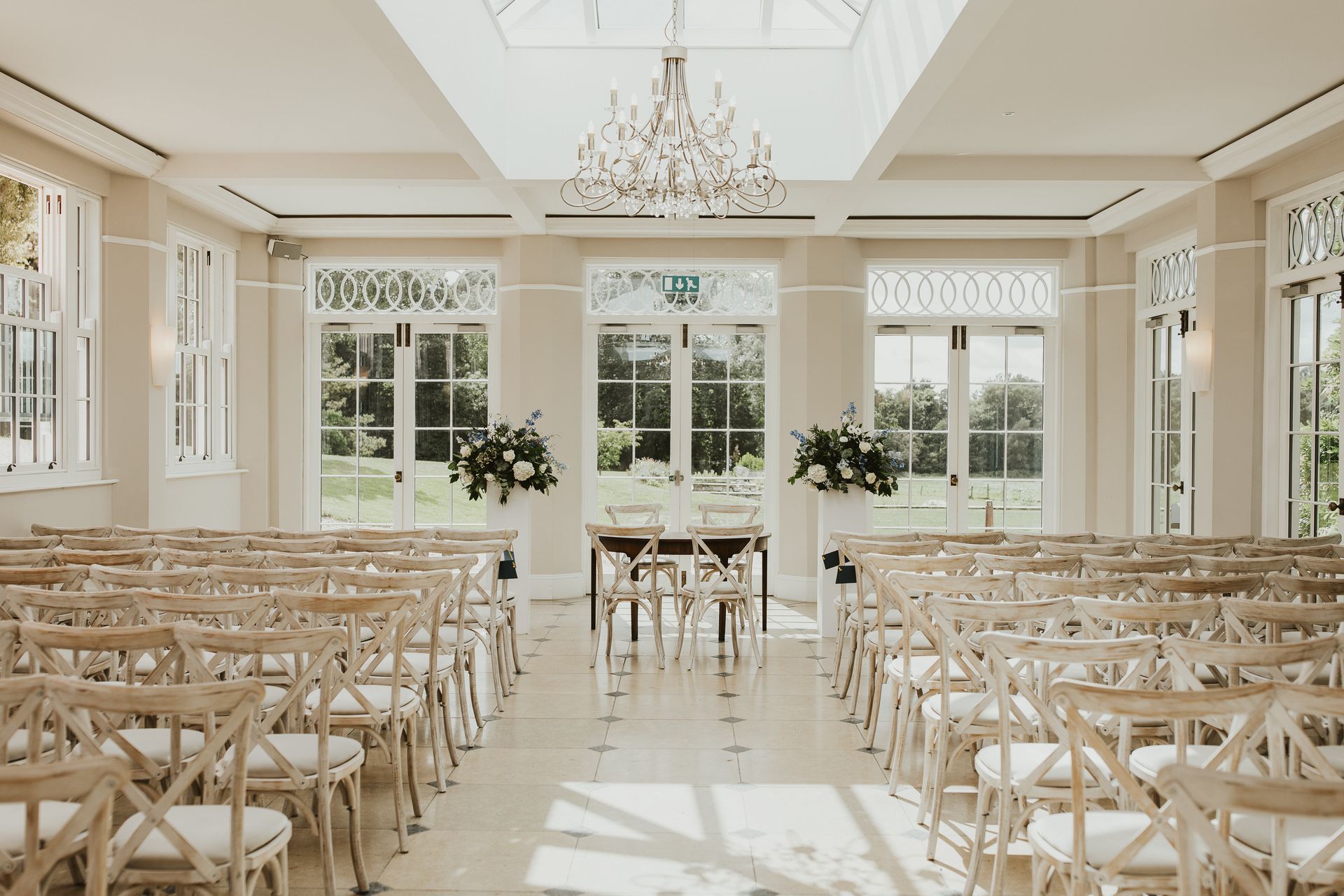a room filled with rows of wooden chairs and a table .