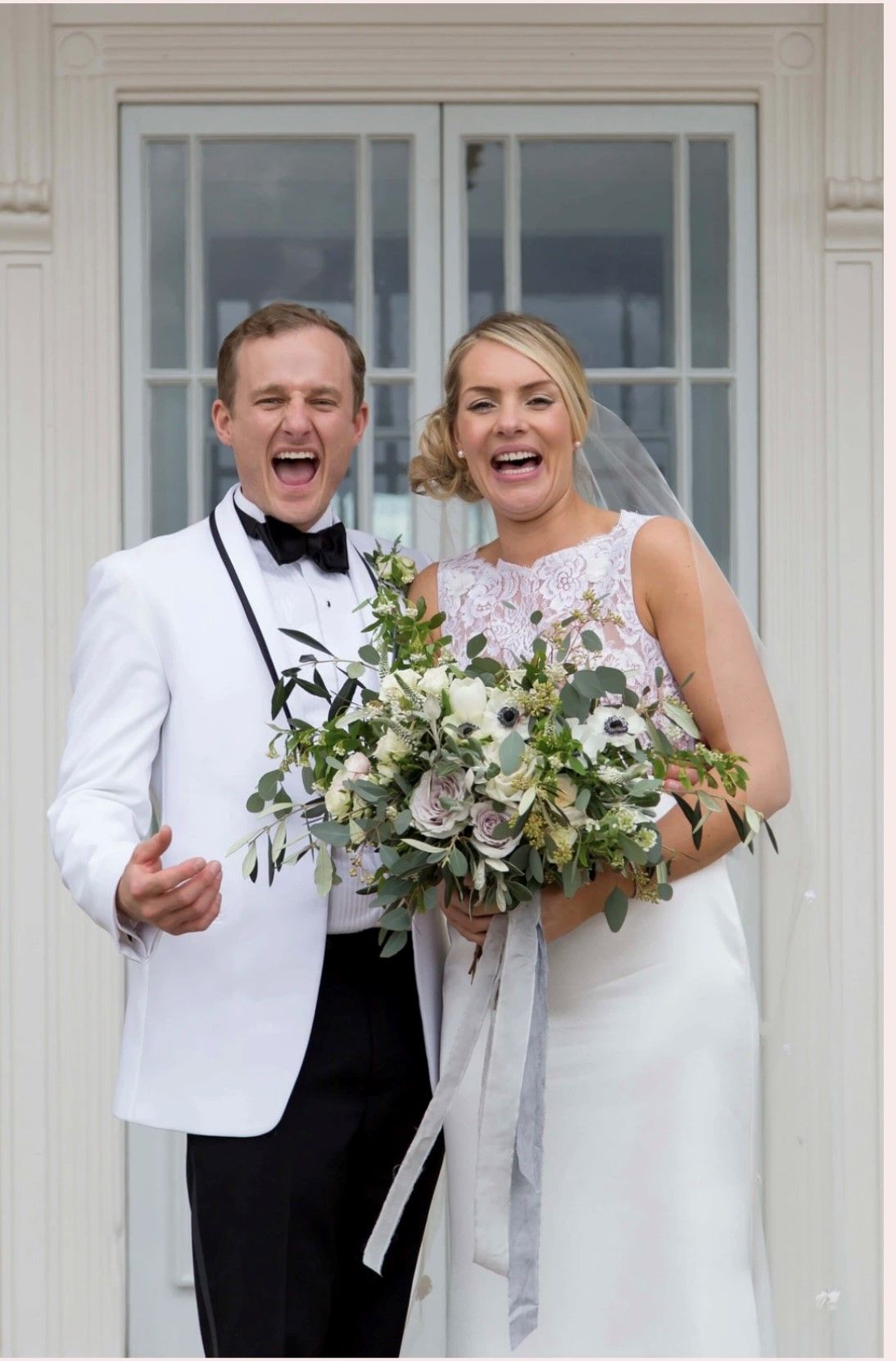 a bride and groom are posing for a picture in front of a door .