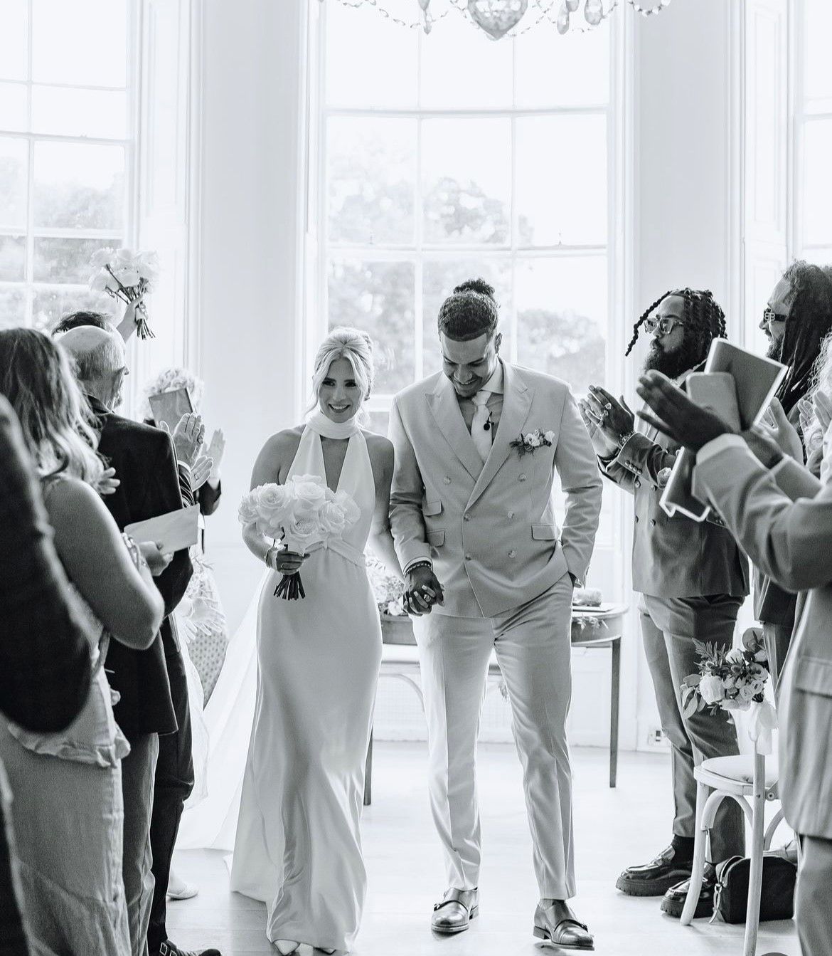 a bride and groom are dancing in front of a crowd at their wedding reception .