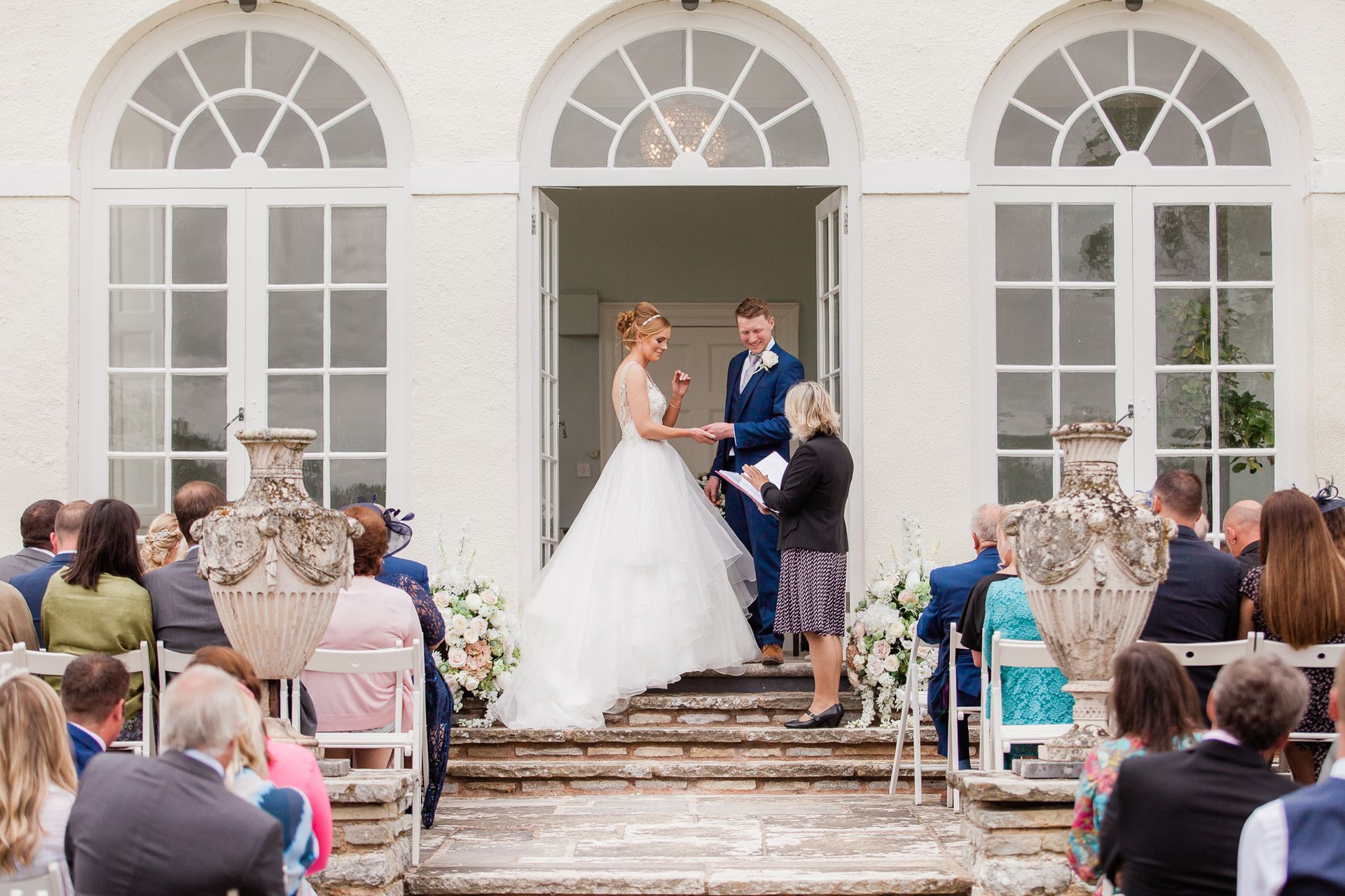 a bride and groom are getting married in front of a crowd of people.