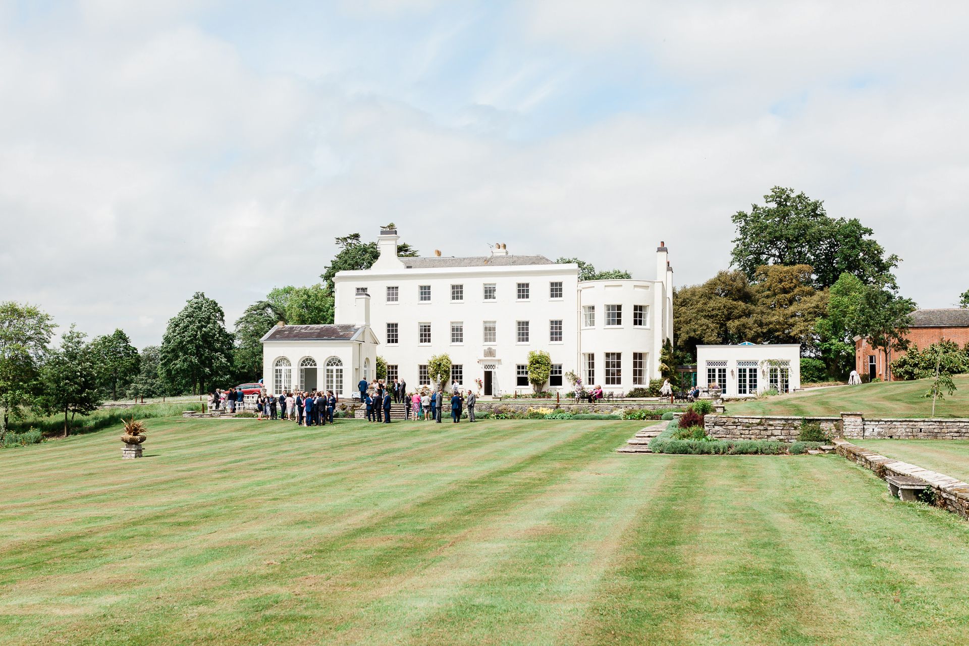 a group of people are standing in front of a large white building.