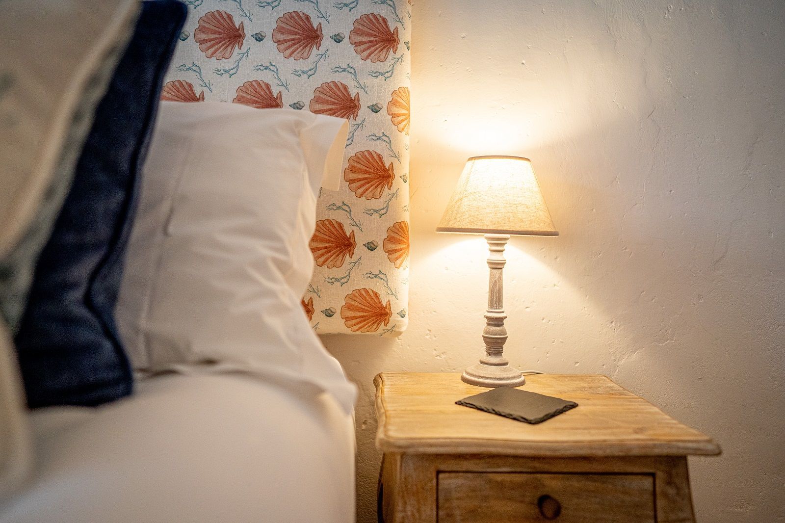 there is a lamp on the nightstand next to the bed .