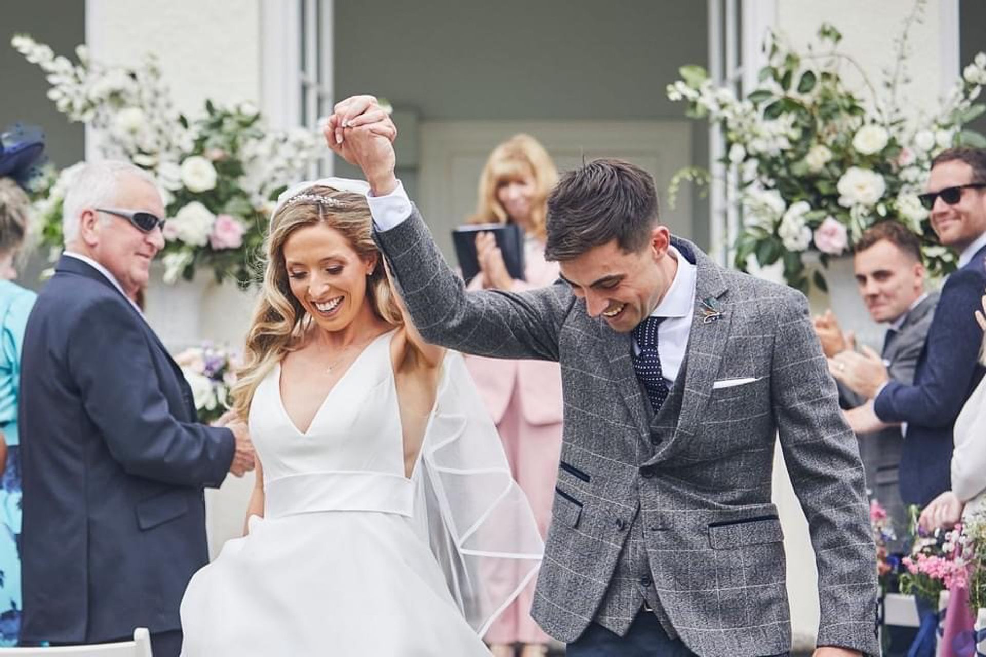 a bride and groom are walking down the aisle at their wedding holding hands .