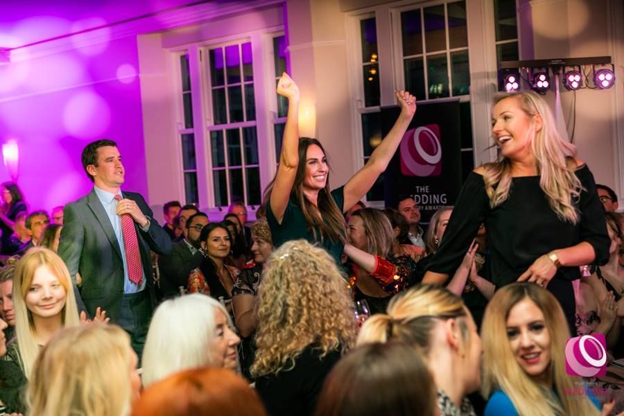 a group of people are dancing in a room at a party .