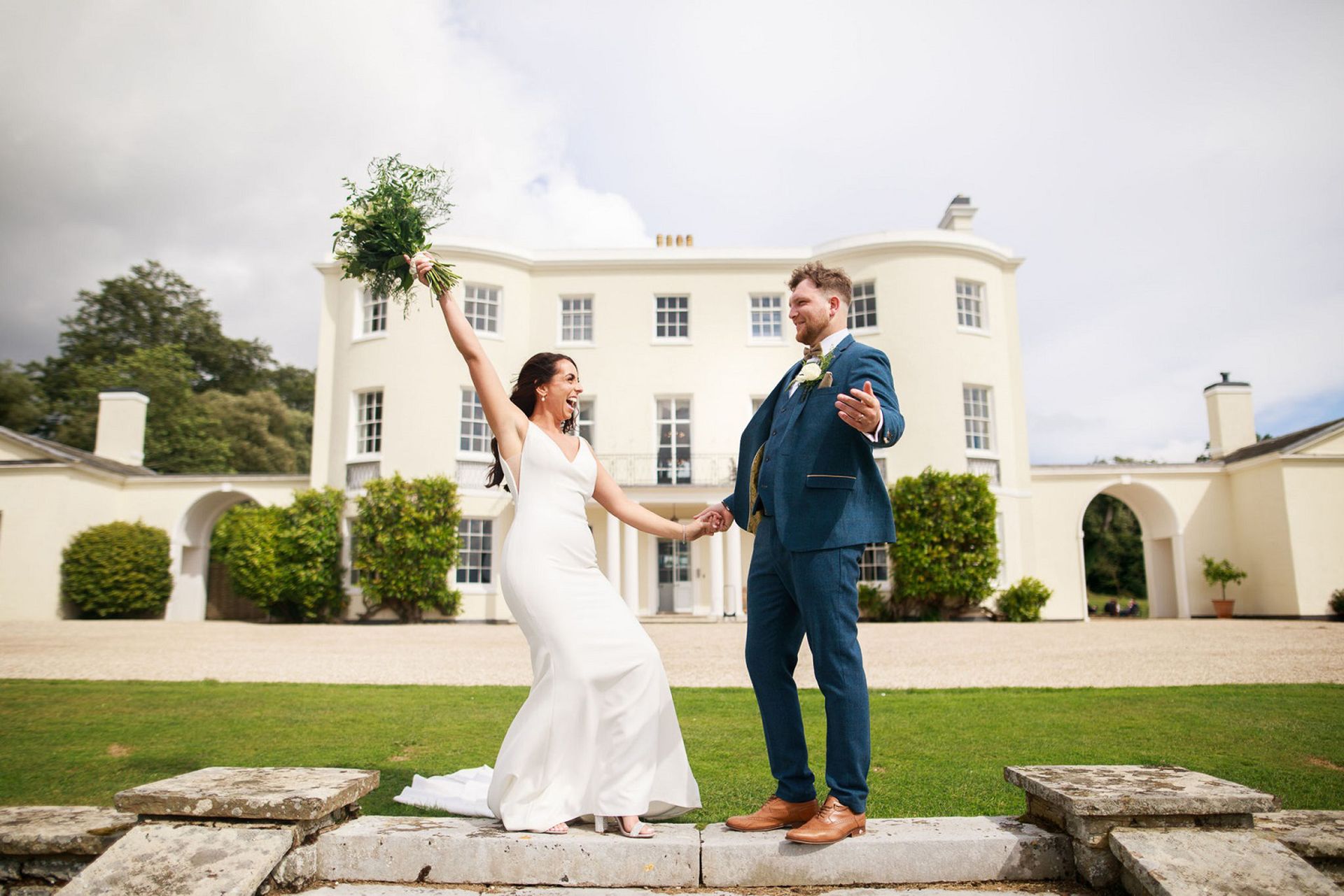 a bride and groom are posing for a picture in front of the wedding venue in Exeter, Devon.