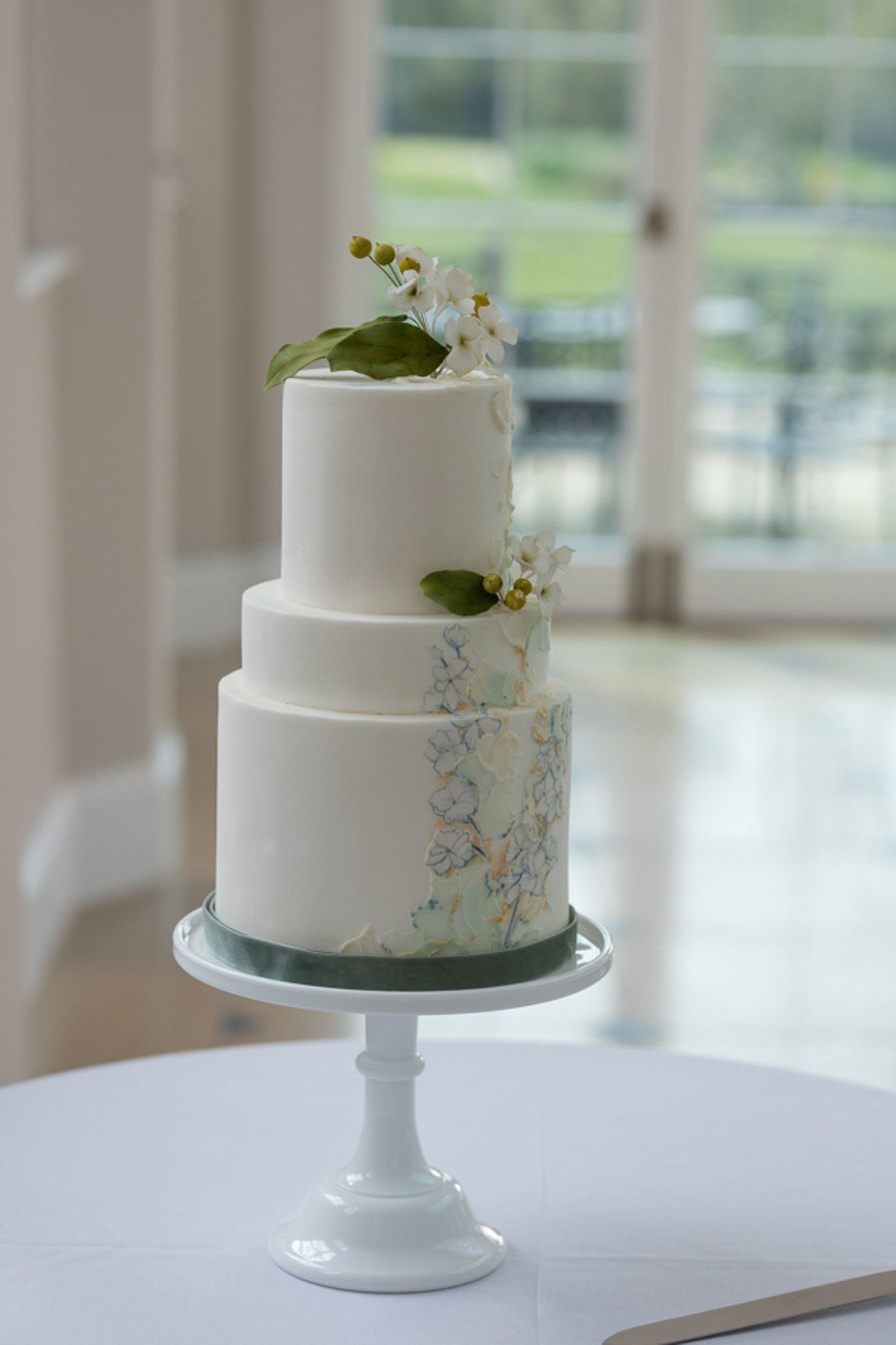 a white wedding cake is sitting on top of a white table .