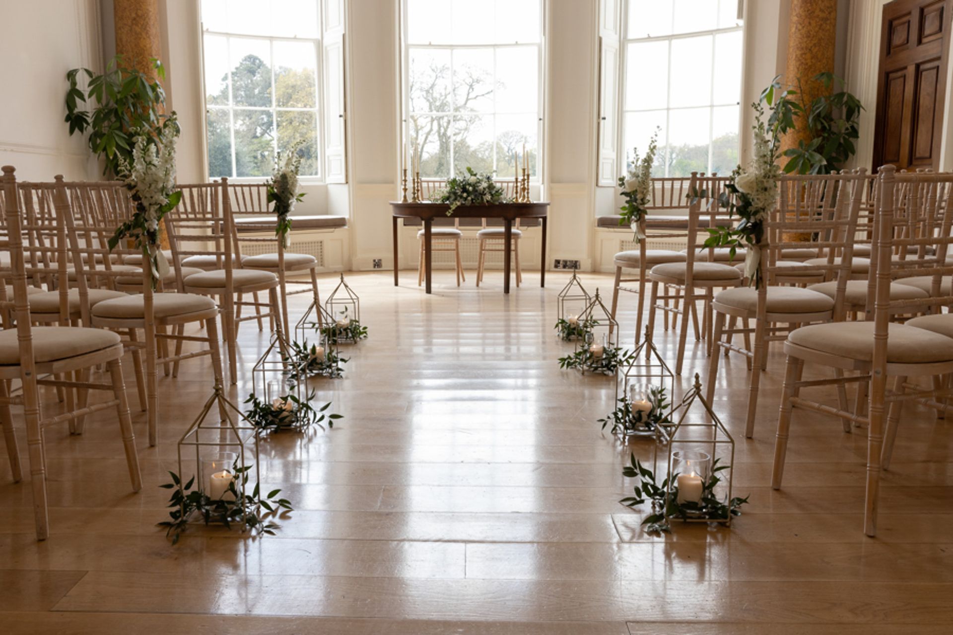 a room filled with chairs and candles for a wedding ceremony .