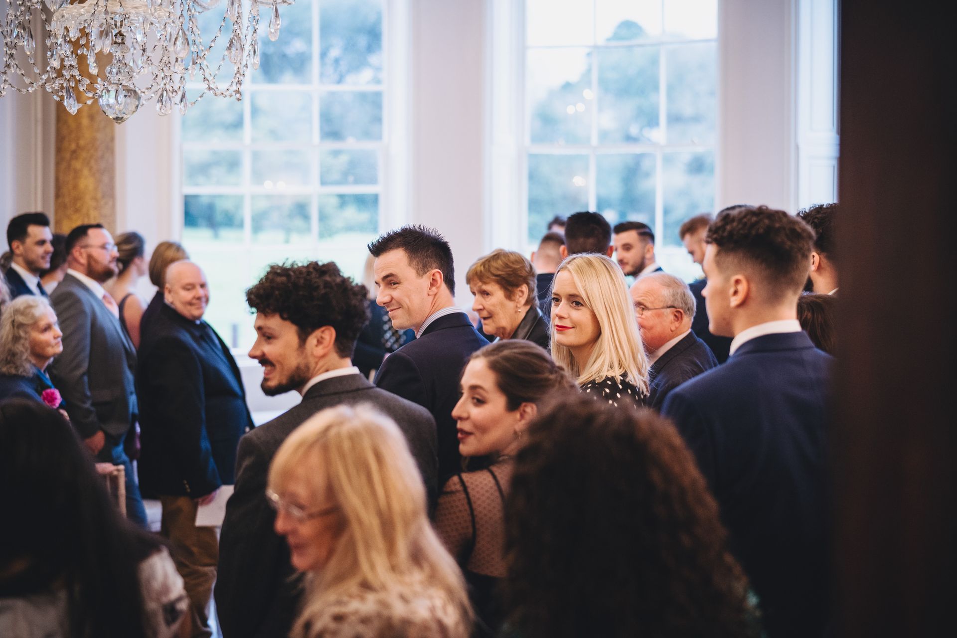 a large group of people are standing in a room .