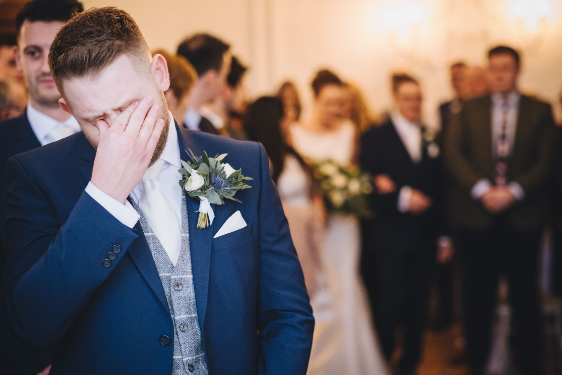 a man in a suit is crying during a wedding ceremony .