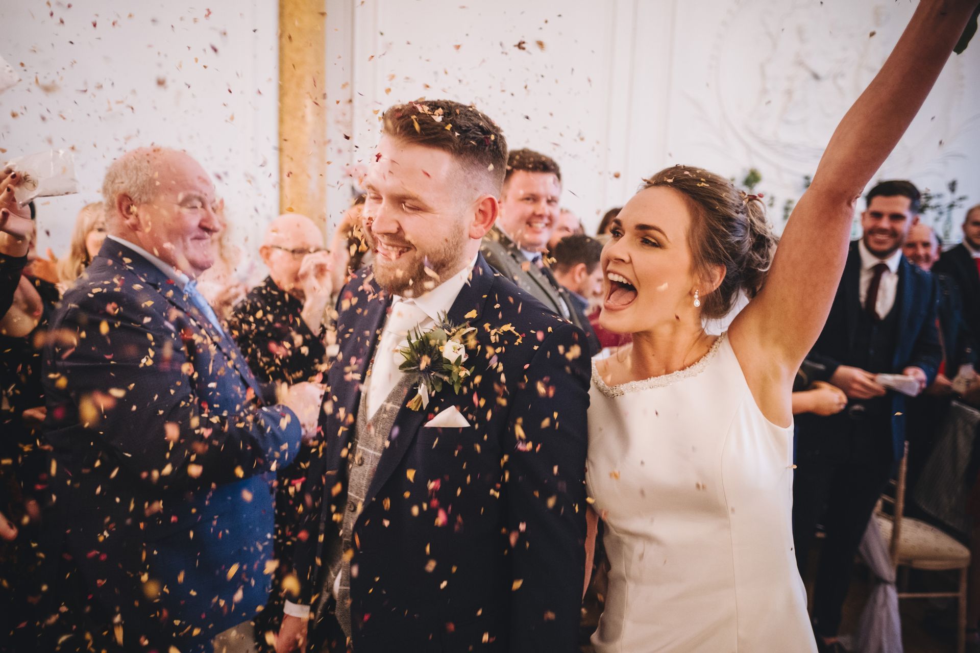 a bride and groom are being showered with confetti at their wedding reception .