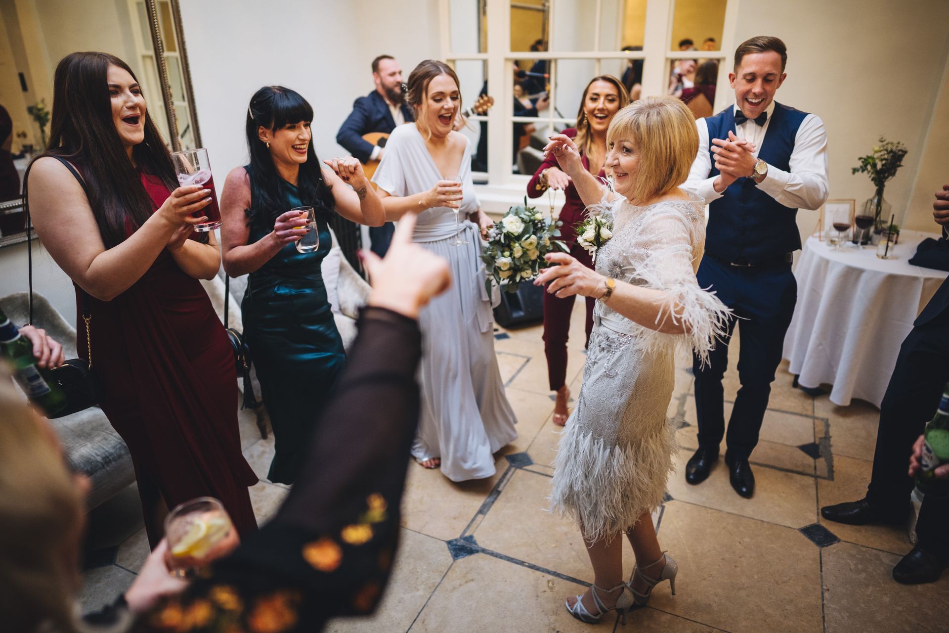 a group of people are dancing at a wedding reception .