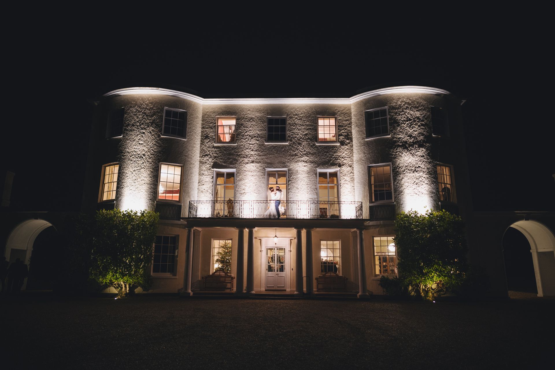the front of a large building is lit up at night .