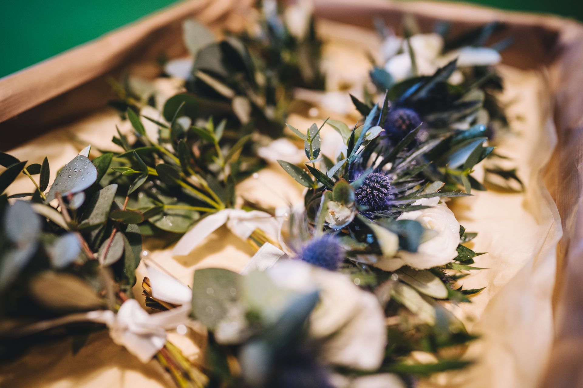 a wooden box filled with flowers and leaves on a table .