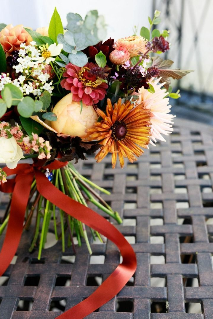a bouquet of flowers with a red ribbon on a table