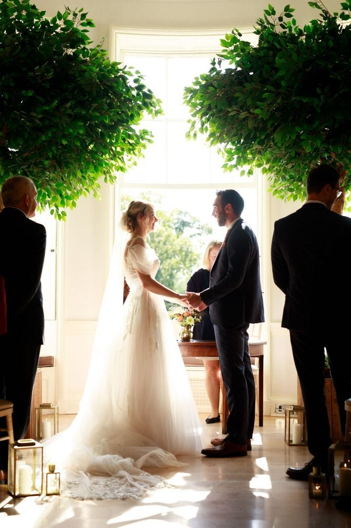a bride and groom are holding hands during their wedding ceremony.