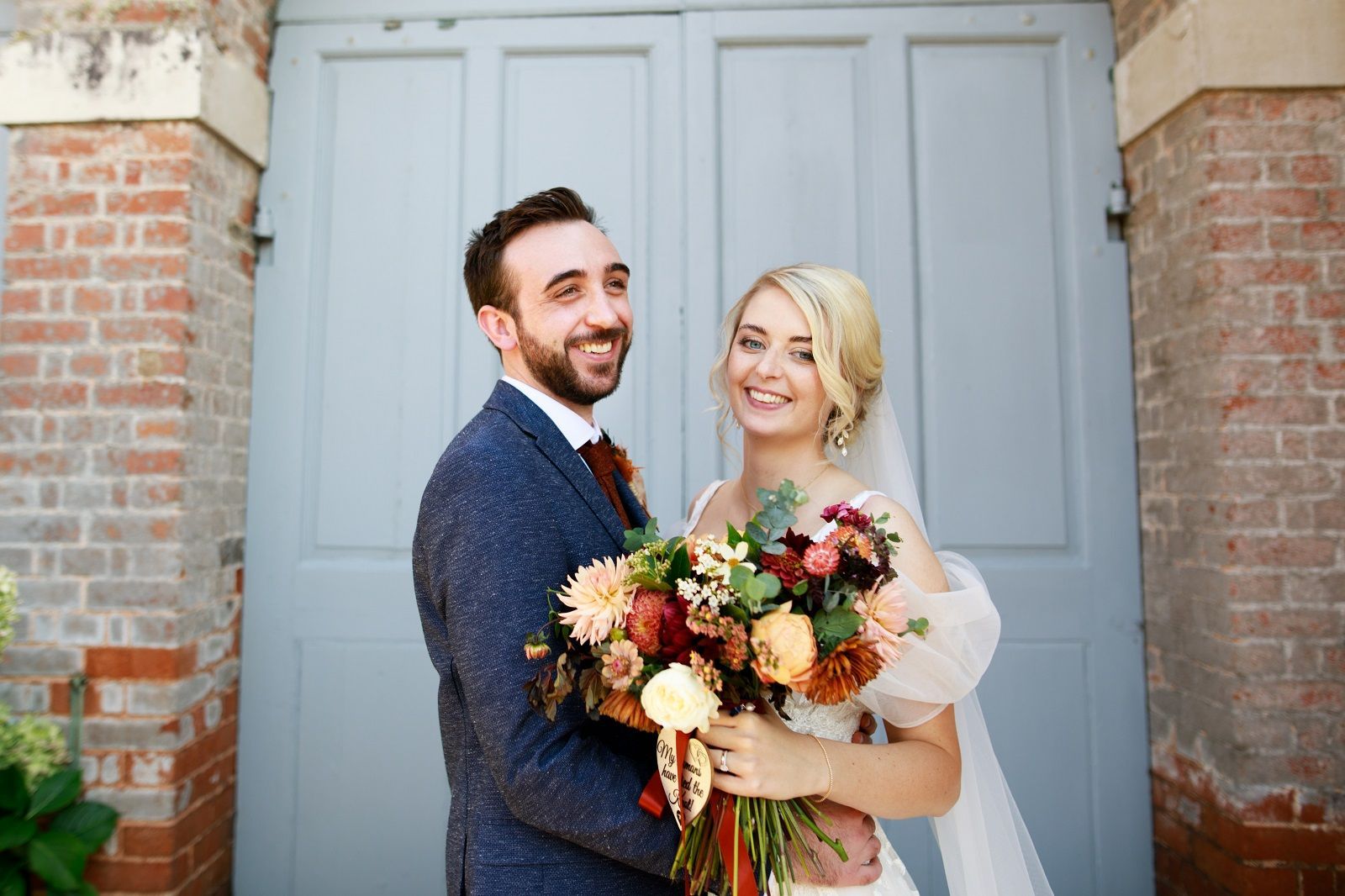a bride and groom are posing for a picture in front of a garage door.