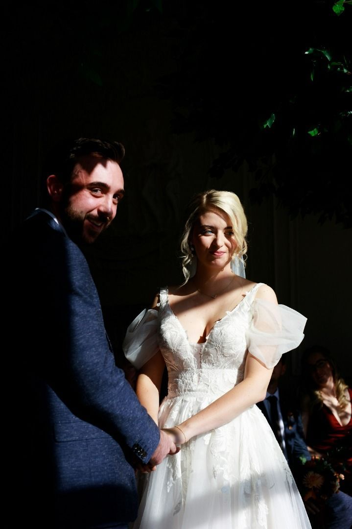 a bride and groom are holding hands during their wedding ceremony.