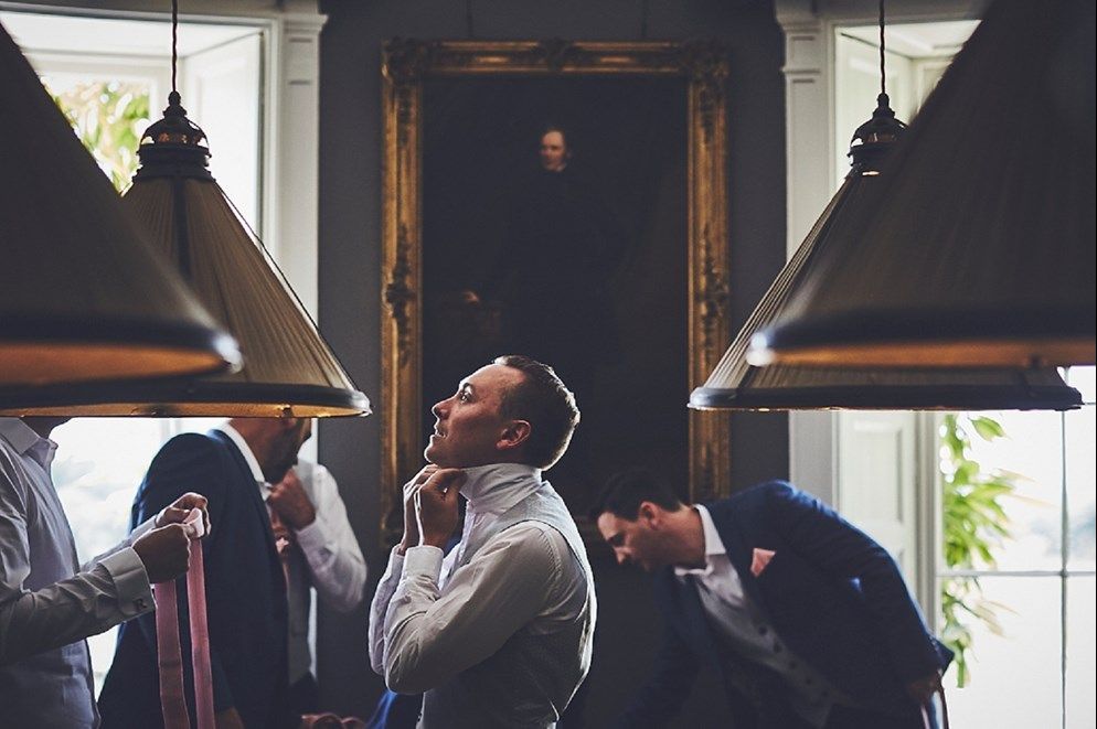 a group of men are getting ready for a wedding .