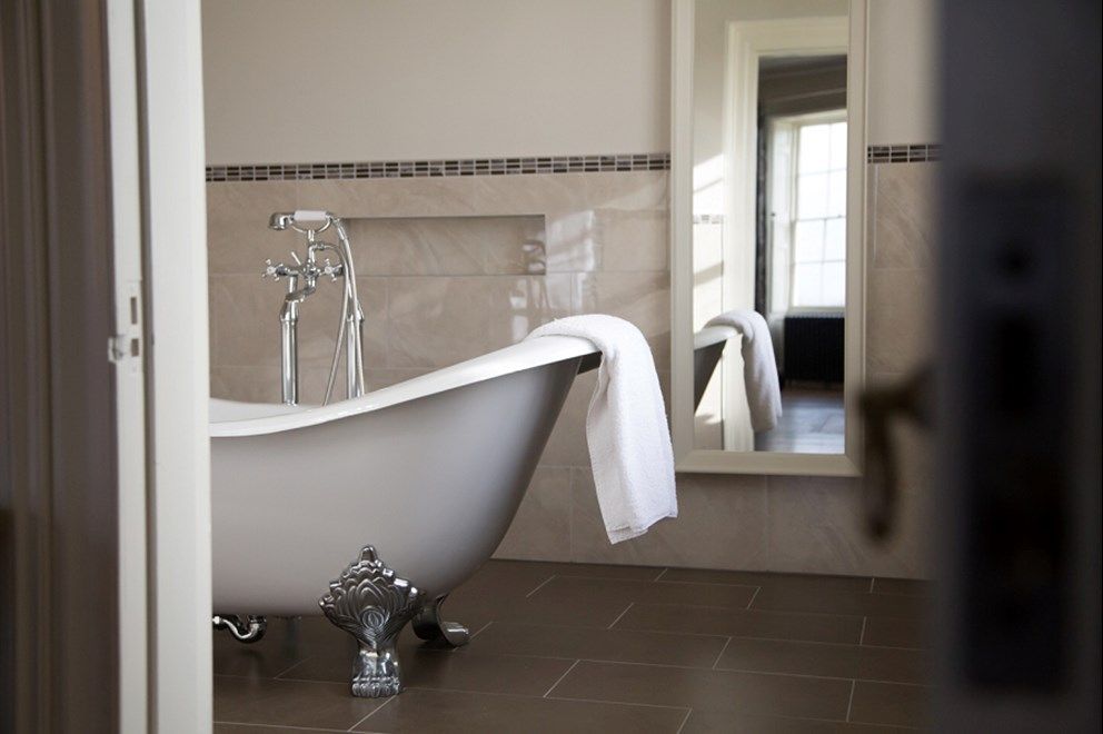 a bathroom with a claw foot tub and a mirror