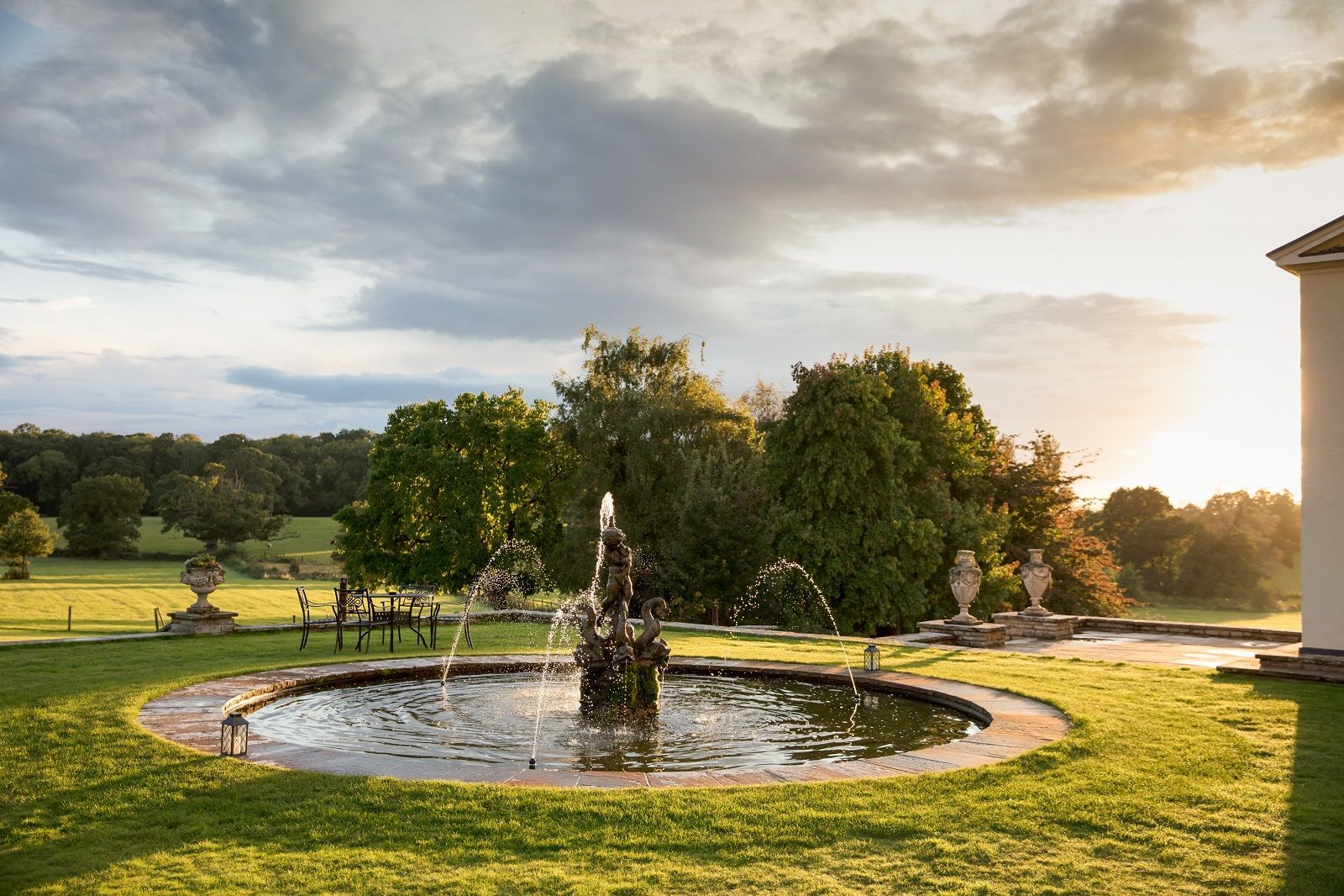 a fountain in the middle of a lush green field