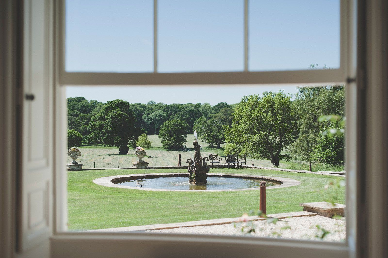 a view of a fountain through an open window .