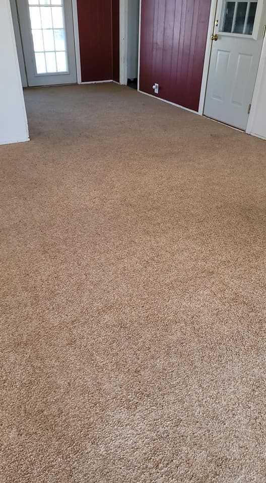 A room with a carpeted floor and a door.