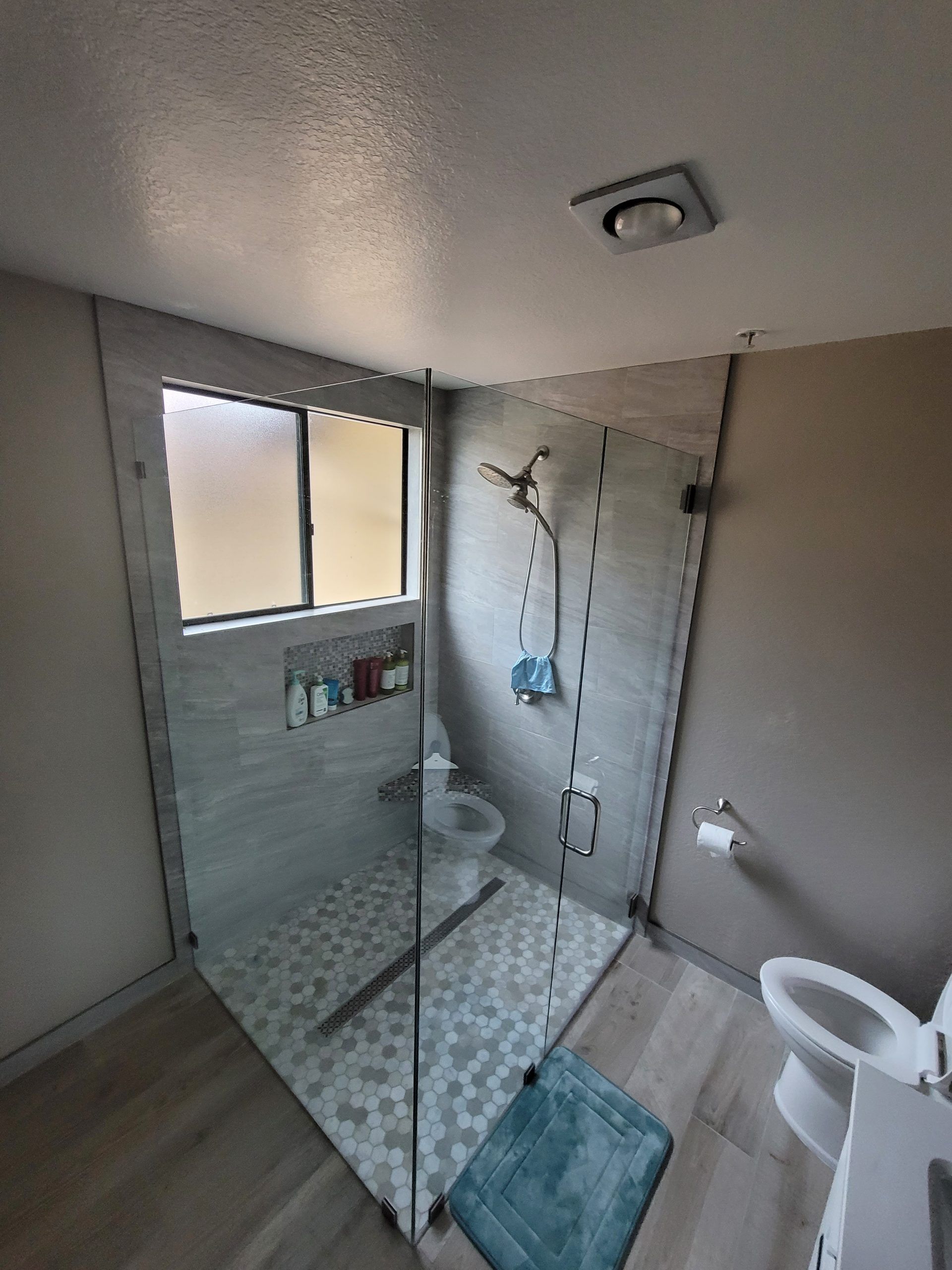 A bathroom with a walk in shower and a bathtub from a Bathroom remodel in San Diego CA by Team Renovate
