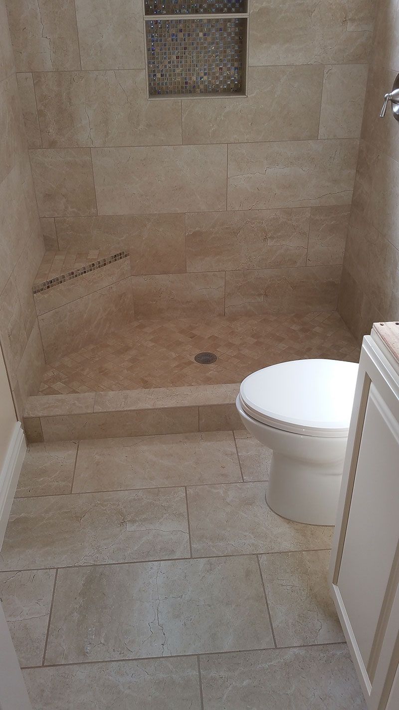 A bathroom with a toilet and a walk in shower from a Bathroom remodel in San Diego CA by Team Renovate