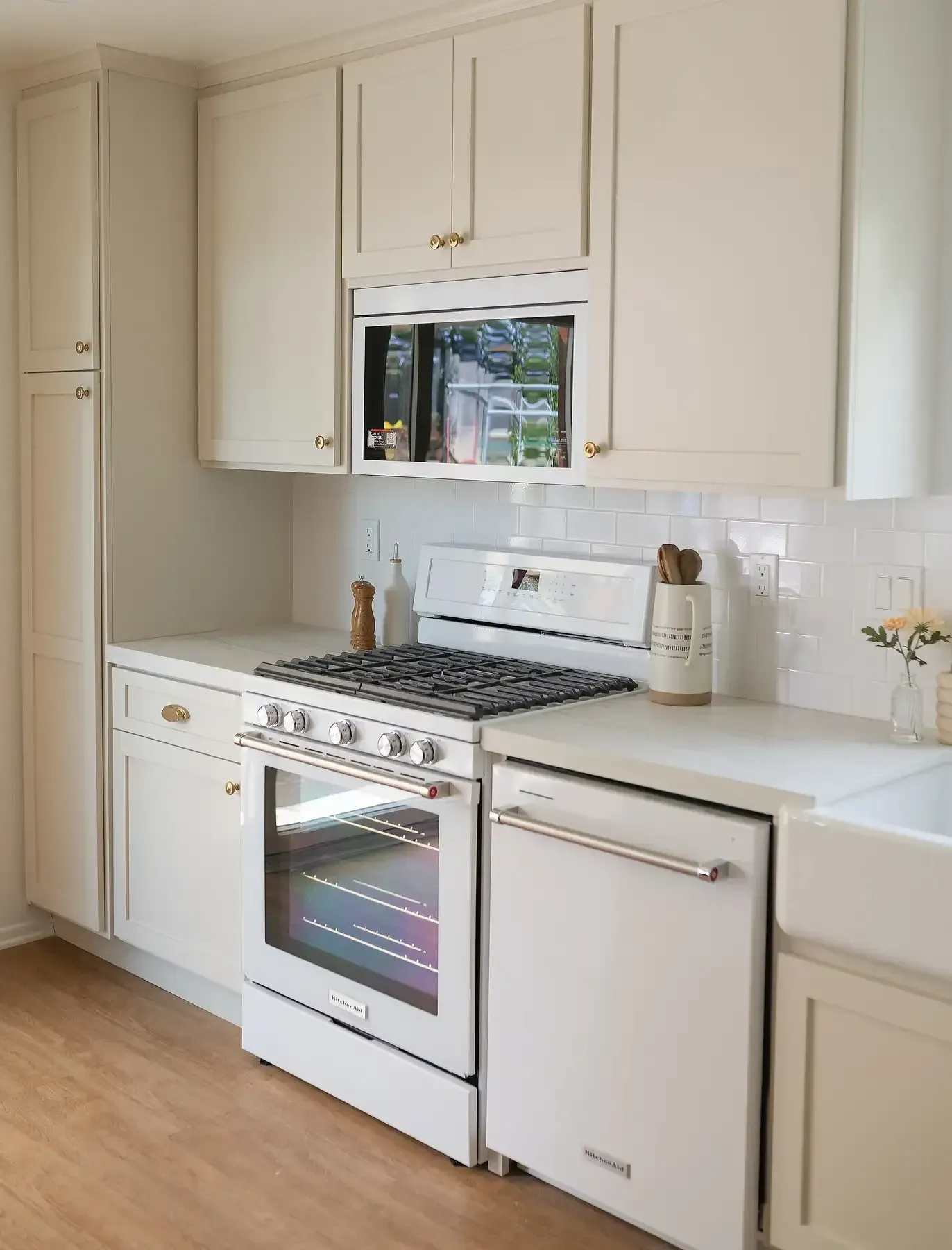 Team Renovate - White kitchen with oven, dishwasher, cabinets, and microwave.