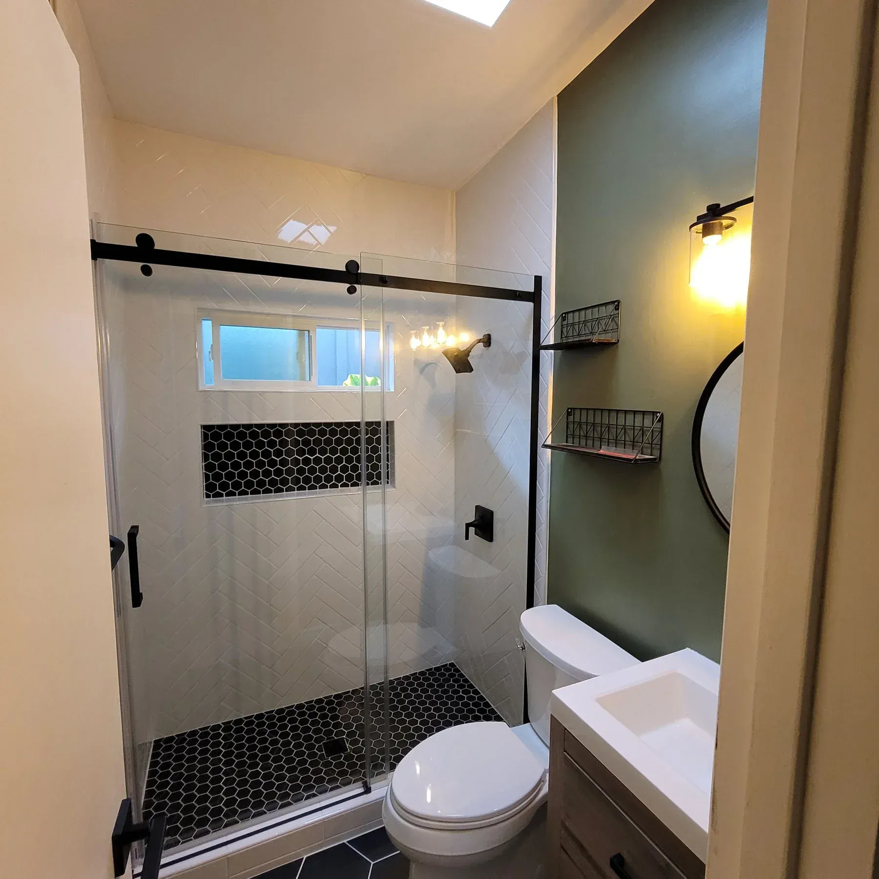 A bathroom with a walk in shower and a window from a Bathroom remodel in San Diego CA by Team Renovate