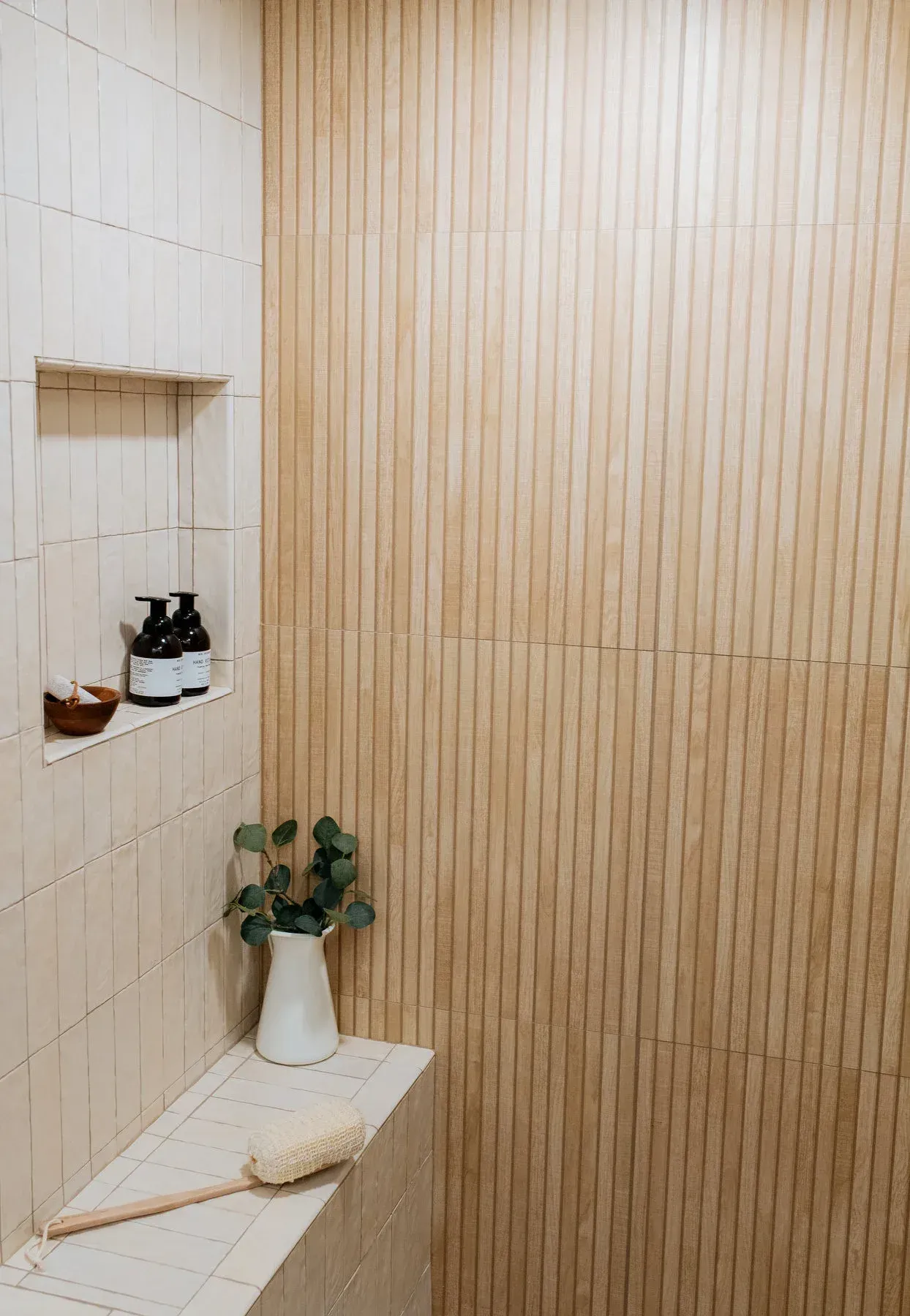 A bathroom with a shower , a shelf , a plant and a brush. from a Bathroom remodel in San Diego CA by Team Renovate