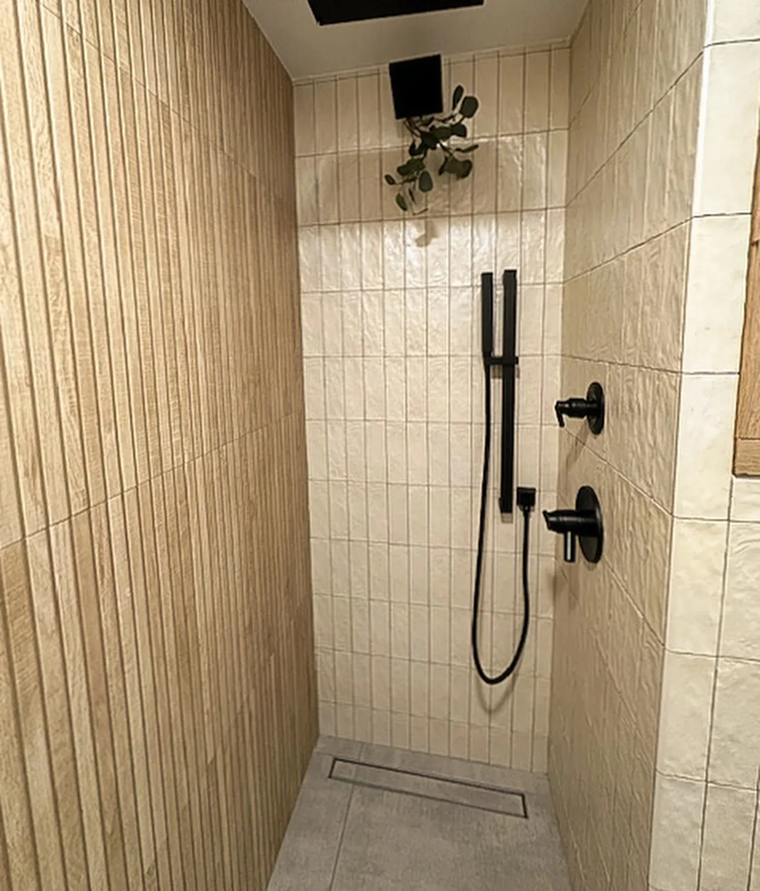 A bathroom with a walk in shower and a plant on the ceiling. from a Bathroom remodel in San Diego CA by Team Renovate