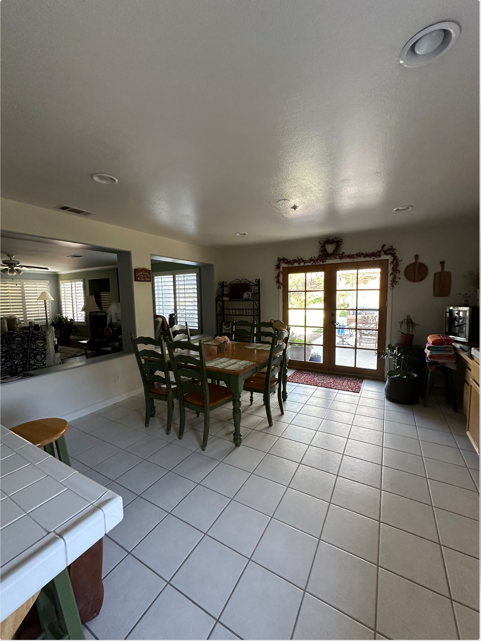 Team Renovate - Kitchen with dining table, chairs, and tiled floor, leading to a door and outside.
