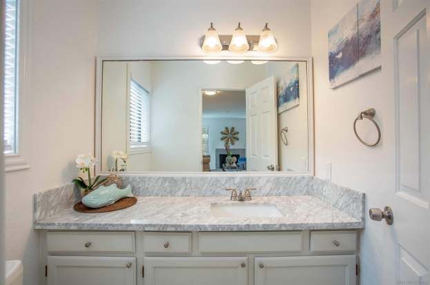 A bathroom with a sink and a large mirror from a Bathroom remodel in San Diego CA by Team Renovate