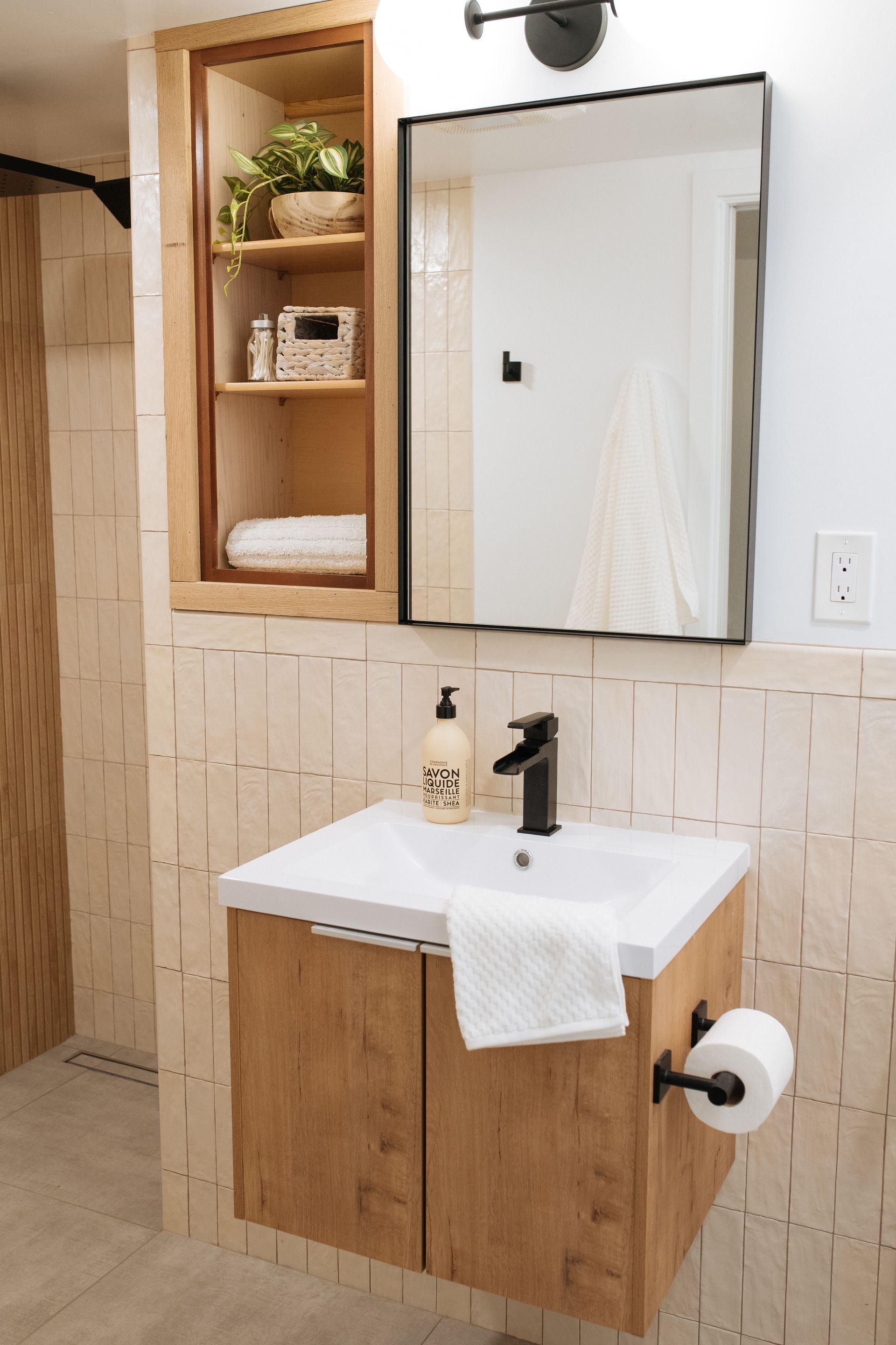 A bathroom with a sink , mirror and cabinet from a Bathroom remodel in San Diego CA by Team Renovate