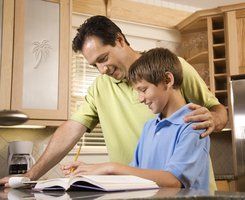boy is taking notes with his dad