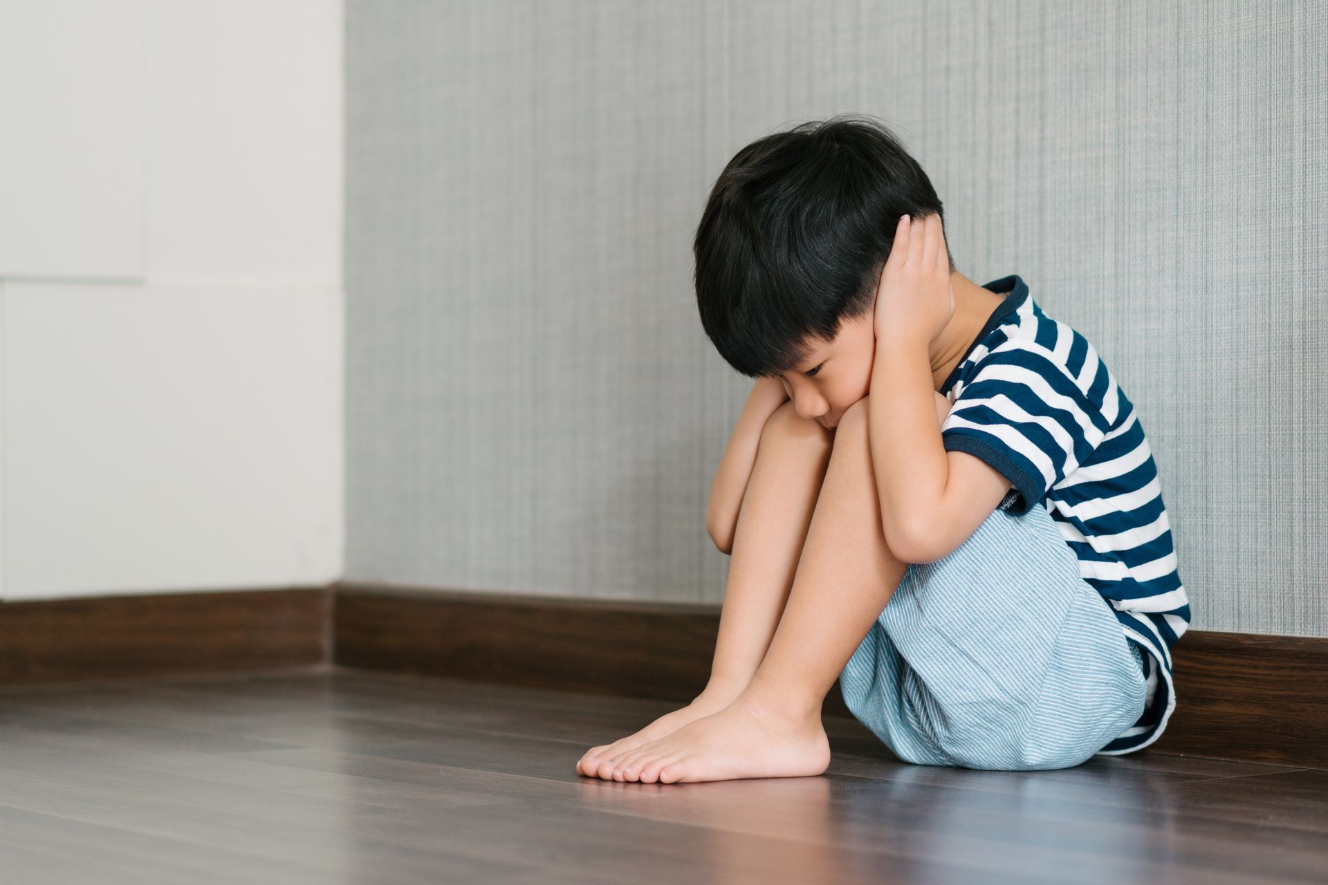 A boy covering his ears