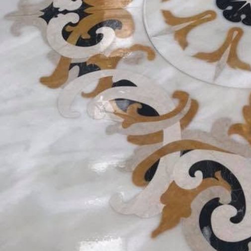 Tessuto bianco con volute floreali sovrapposte in oro e nero, probabilmente un motivo decorativo.