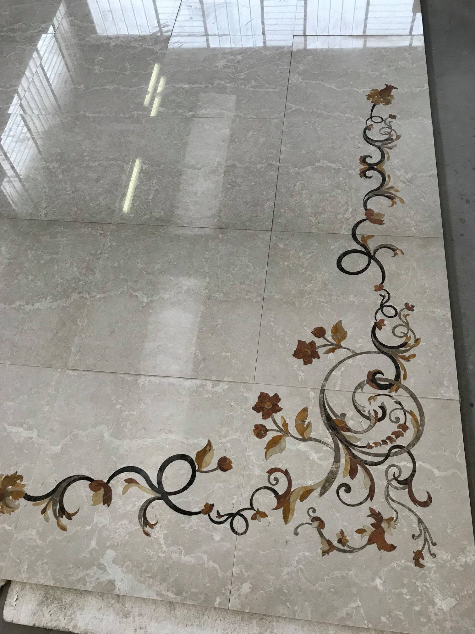 Pavimento piastrellato lucido con bordo decorativo floreale nei toni del marrone e dell'oro lungo un angolo
