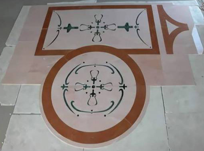 Decorazione per pavimento con un disegno rettangolare e circolare in stile rangoli marrone su piastrelle chiare