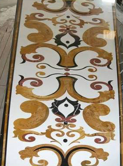 Piastrelle decorative con motivo floreale nei colori oro, marrone, bianco e nero su superficie lucida.
